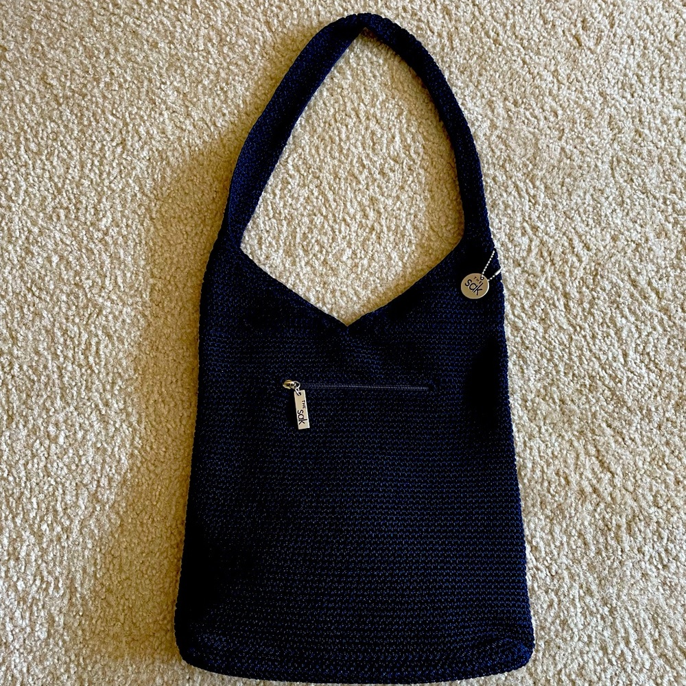 Navy Sak shoulder bag with one inside pocket and one on the outer side.
